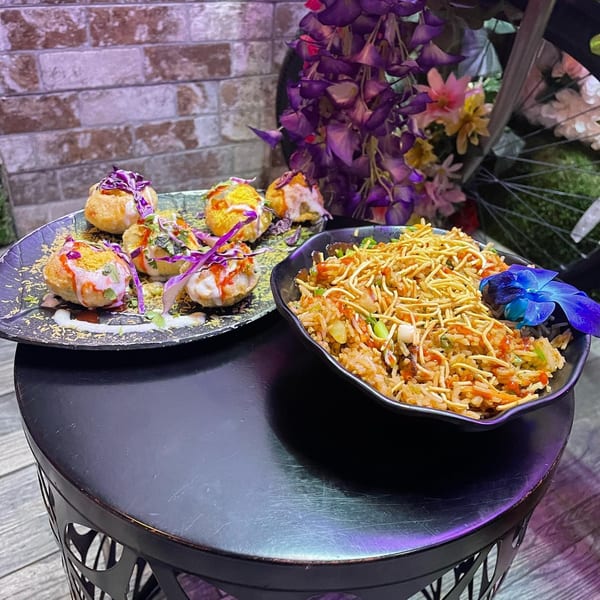 Indian street food: pani puri with sauces and a bowl of rice with crispy noodles.
